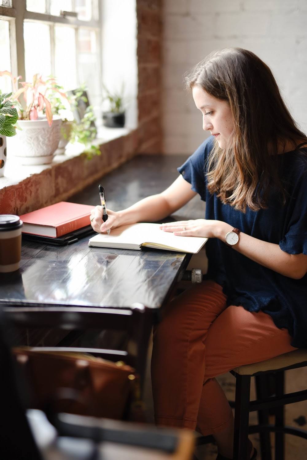 A woman writing something down on a piece of paper.