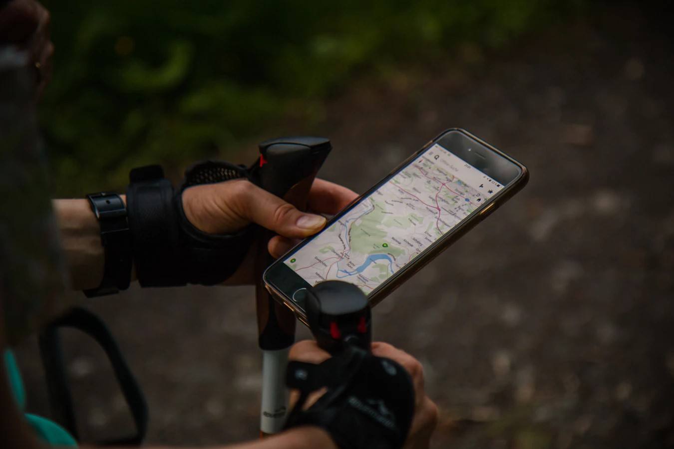 A person hiking while looking at a map on their phone.
