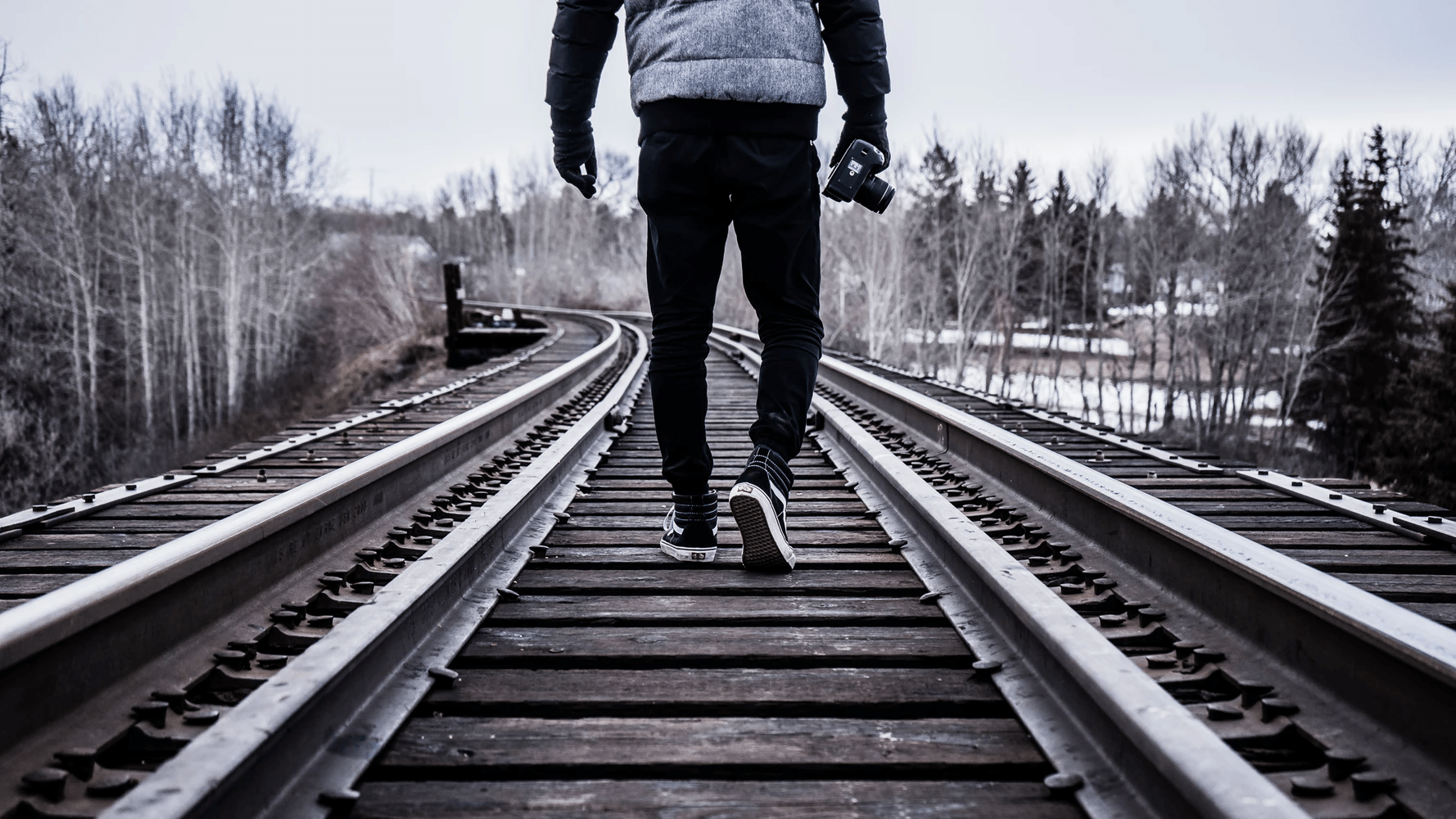 A person walking along a train track.
